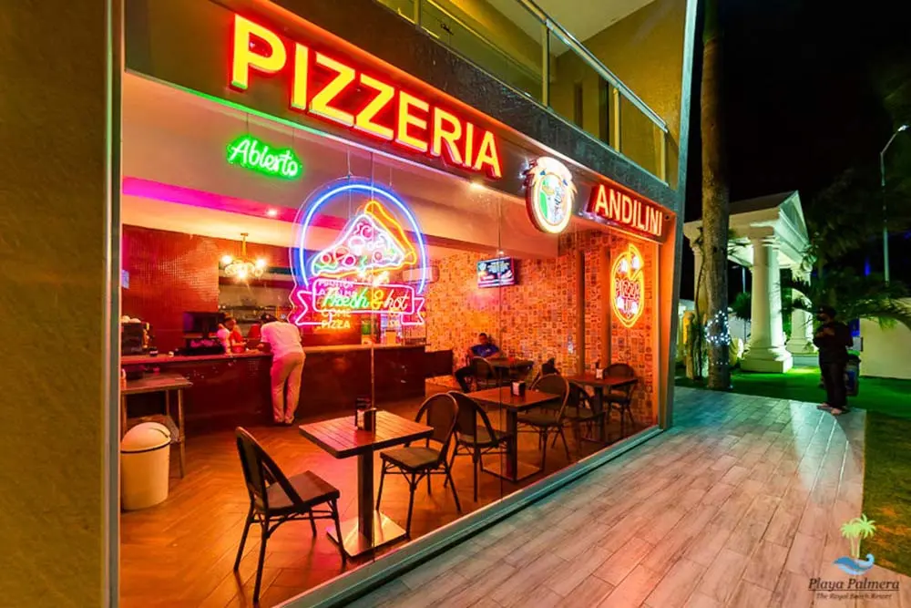 View of the entrance of Andilini Pizzeria at Playa Palmera Beach Resort by night 